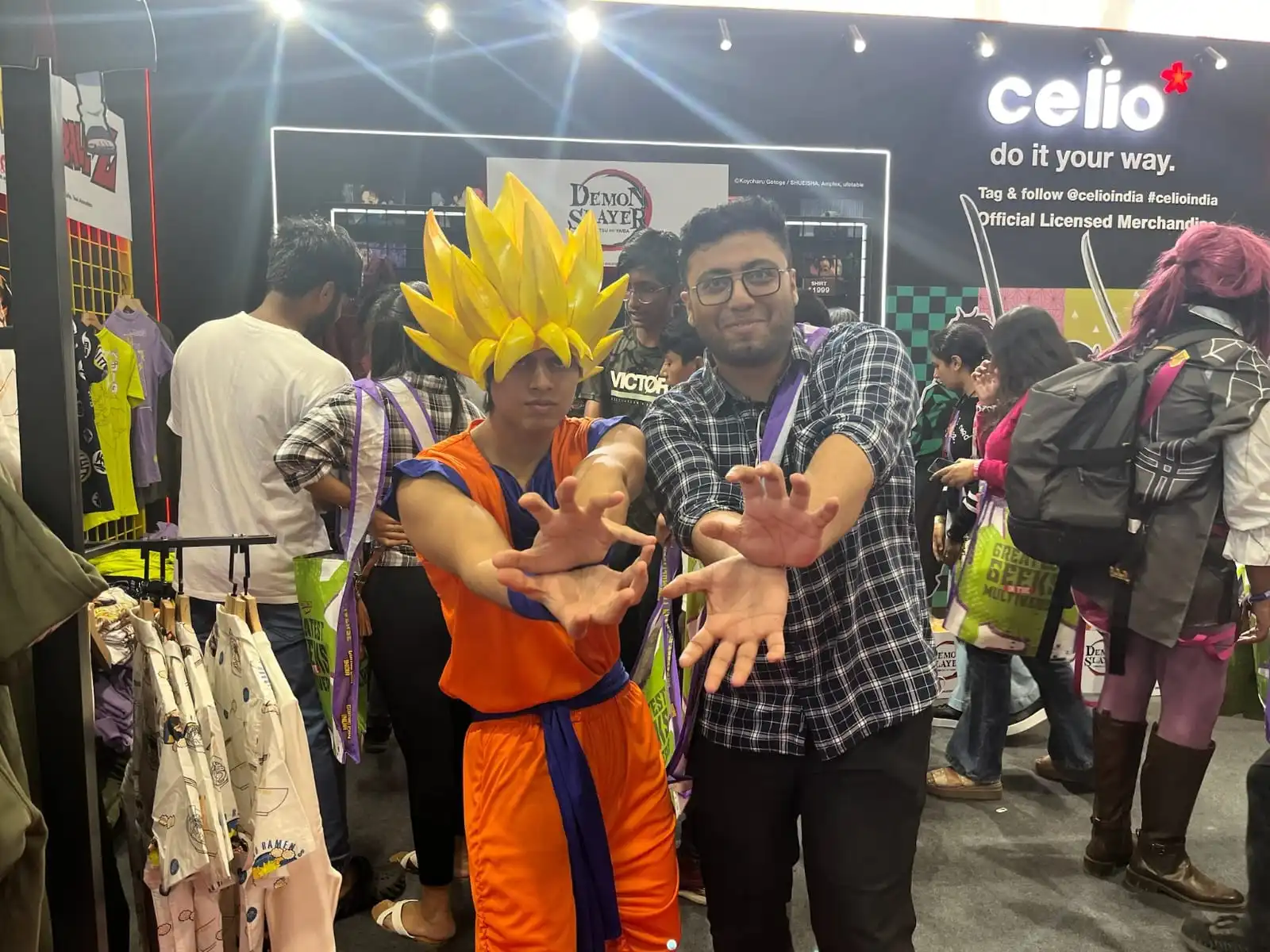 Raghavendra doing a Kamehameha pose beside a Goku cosplayer at a Demon Slayer booth